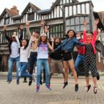 Lewis School students jumping outside Tudor House, Southampton