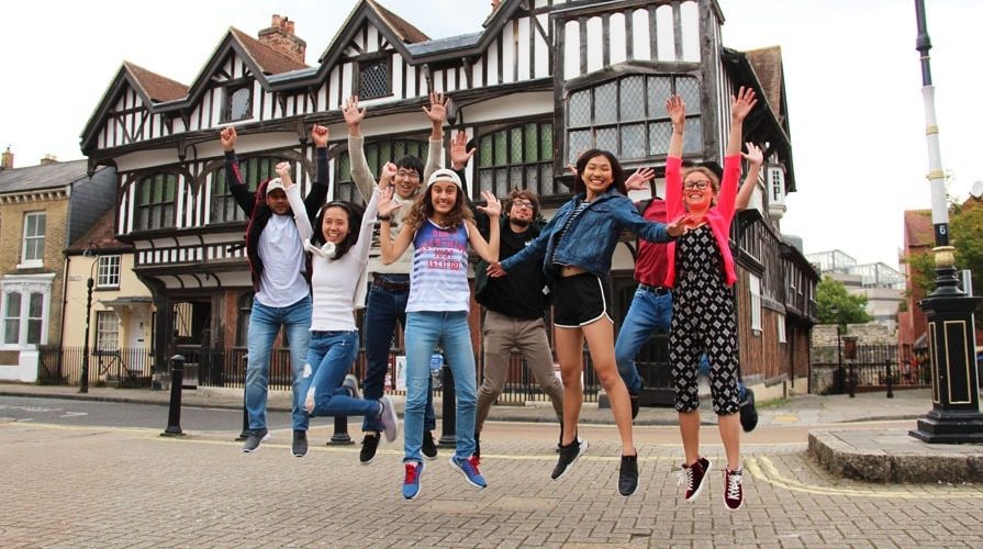 Lewis School students jumping outside Tudor House, Southampton